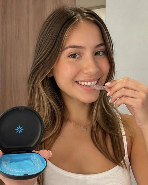 Jovem segurando alinhador transparente